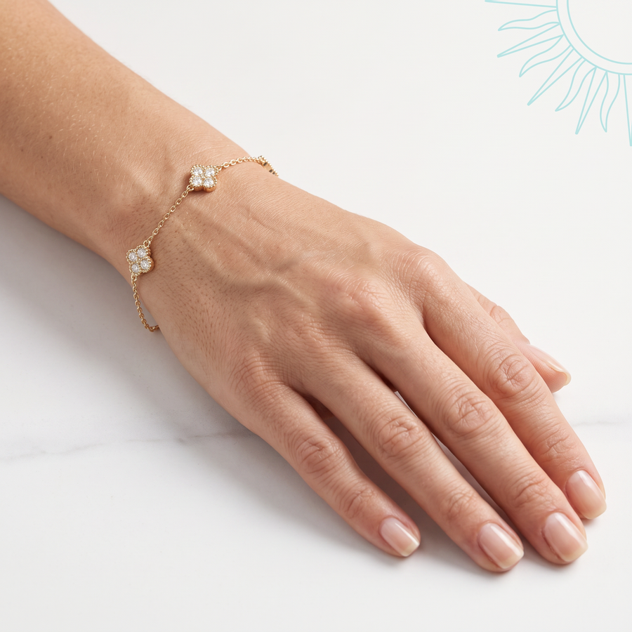 Bracelet Amaranta en vermeil or 18 carats sur argent 925 porté au poignet, main de profil sur fond clair