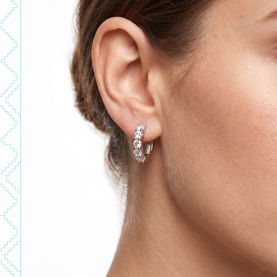 Boucles d'oreilles Aquira en argent sterling 925 portées à l'oreille, vue de profil sur peau claire