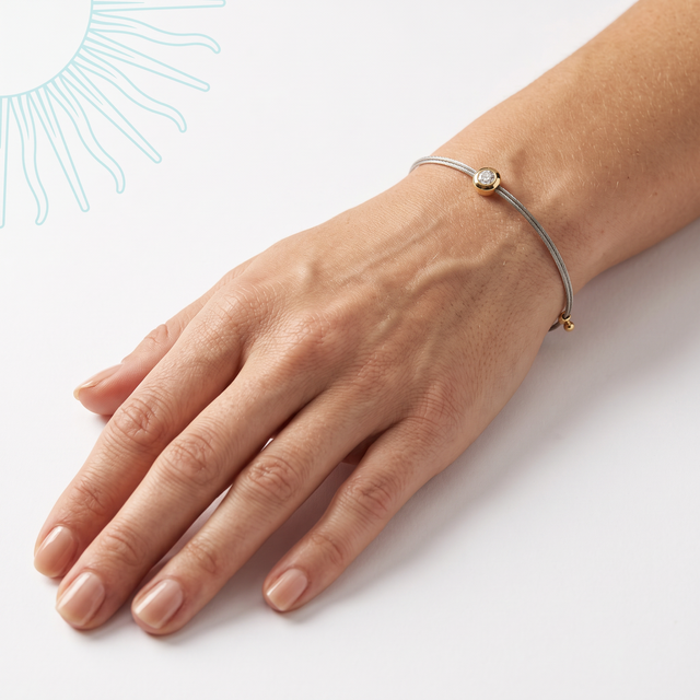 Bracelet Q'aytu en argent sterling 925 porté au poignet, main posée sur fond clair