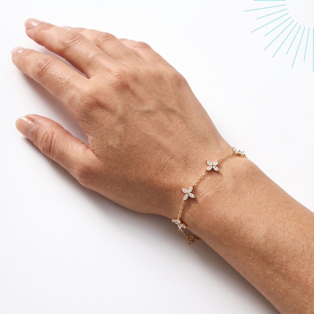 Bracelet Panchay en vermeil or 18 carats sur argent 925 porté au poignet, main posée sur fond blanc